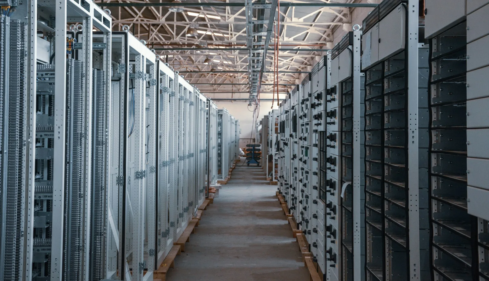 An aisle between two rows of metal server racks in a data center.